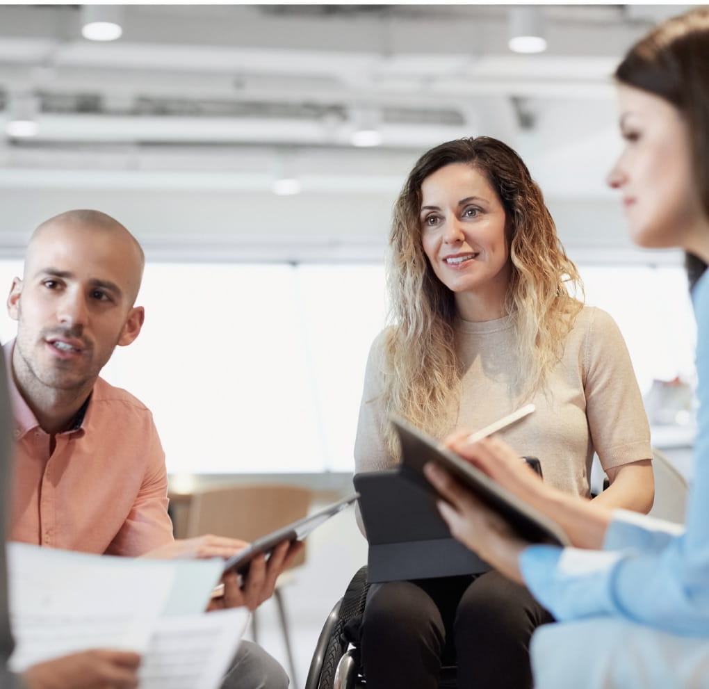 A group of four office workers engage in a workplace meeting.