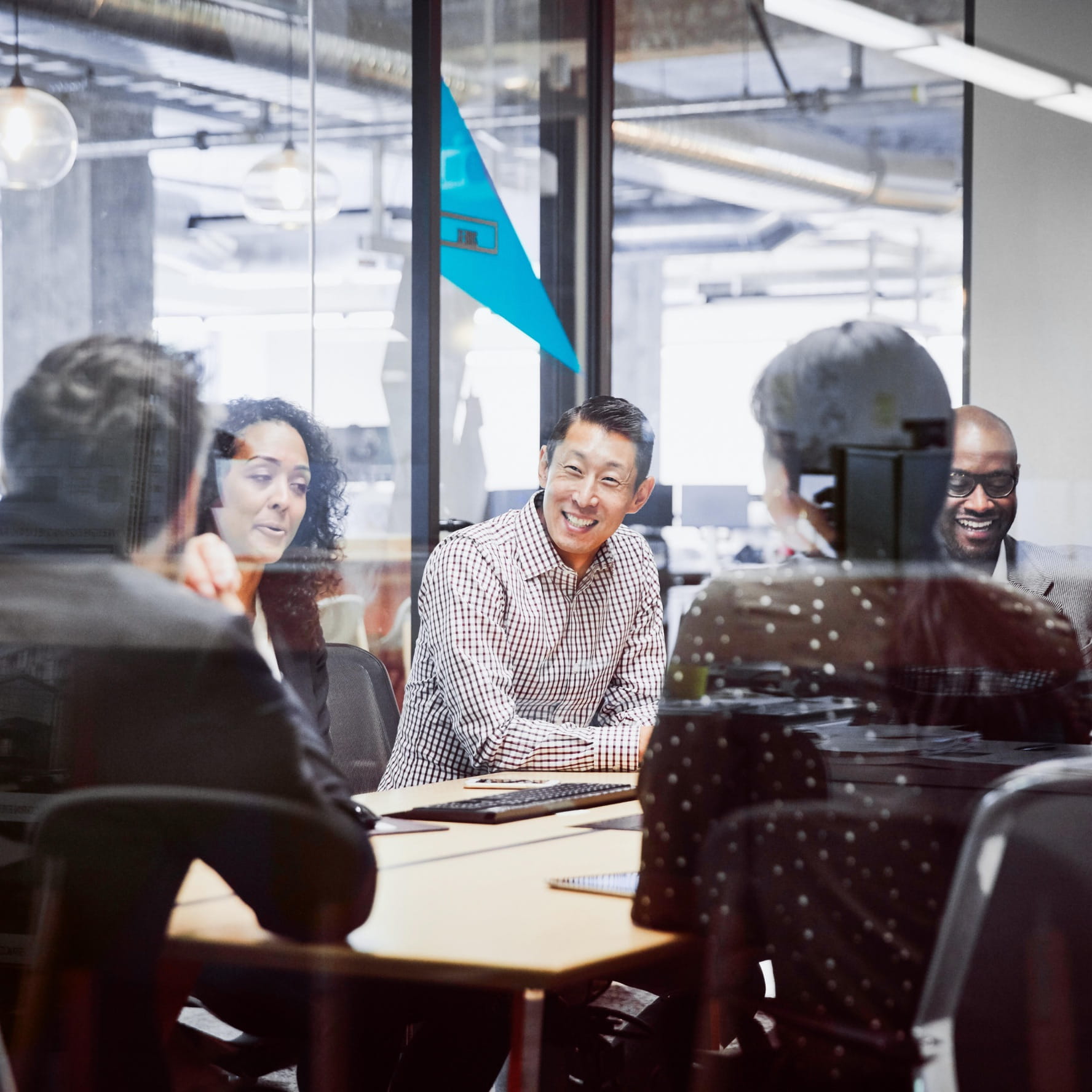 A diverse group of employees are gathered in a meeting room.
